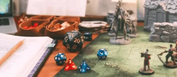 A scene of dice and minifigs across a table, set up and ready to be used for a game.